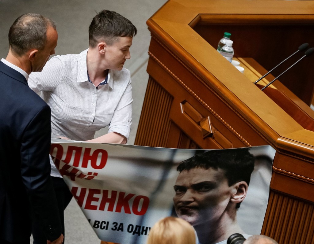Ukrainian pilot and MP Savchenko removes a poster with her portrait as she attends her first session in the parliament after being freed from confinement in Russia as a part of a prisoner swap in Kiev